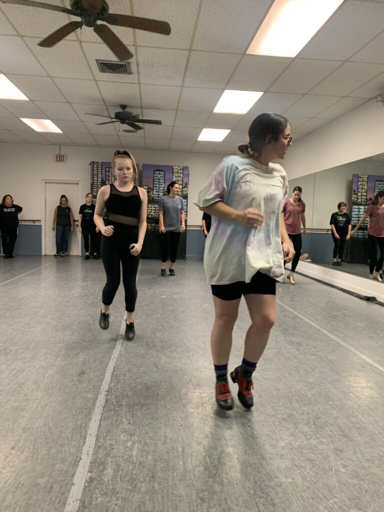 Two people dancing across the floor. 