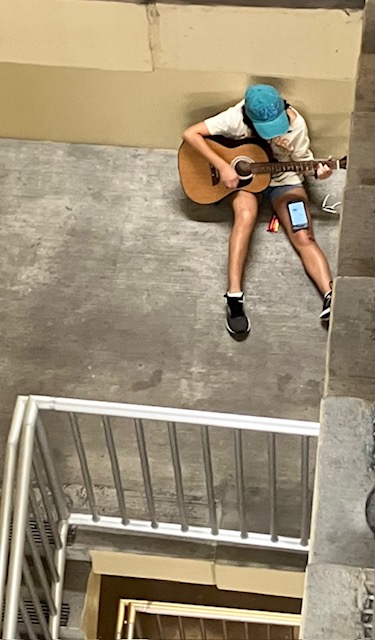 Natalie Natividad strummed her guitar, her lyrics reverberating in the empty space. Photo by Brady Quinn