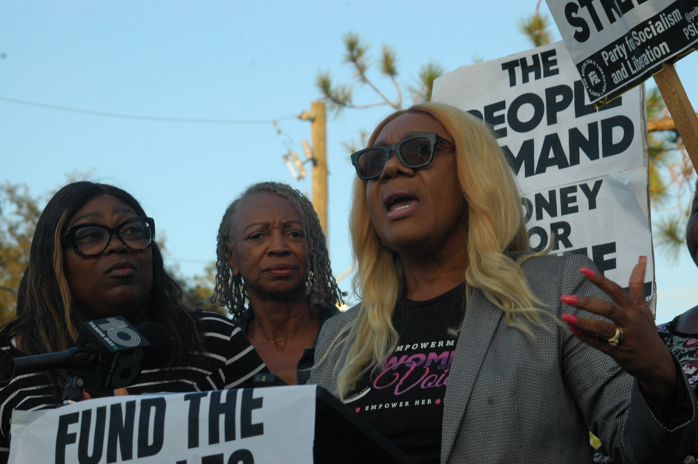 Pastor Kelly speaks surrounded by supporters