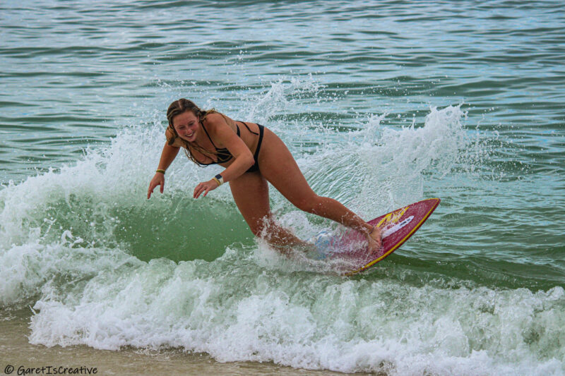 Skimboarder rides a wave