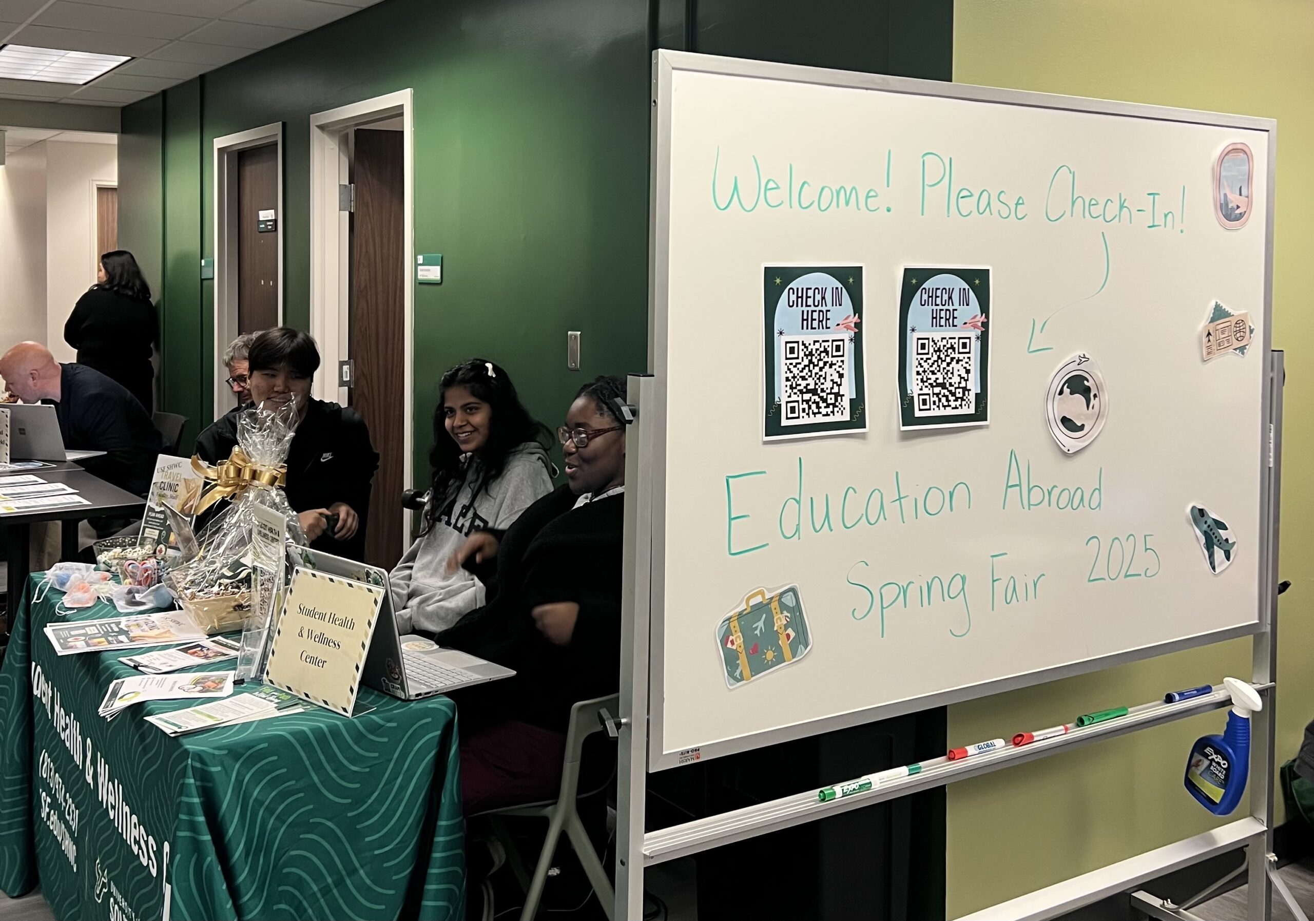 Student representatives from USF Health and Wellness center sit behind the check-in board at the Study Abroad Fair. Photo by Jae Diehl.