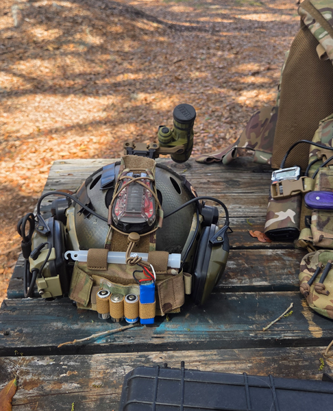 Outside environment. There is a wooden table with a bump helmet on it and other types of training gear.