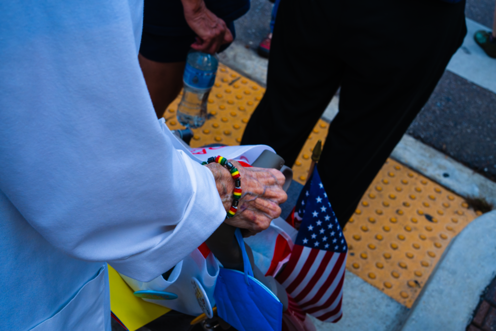 A photo of an older woman's hand holding a bag containing an American flag.
