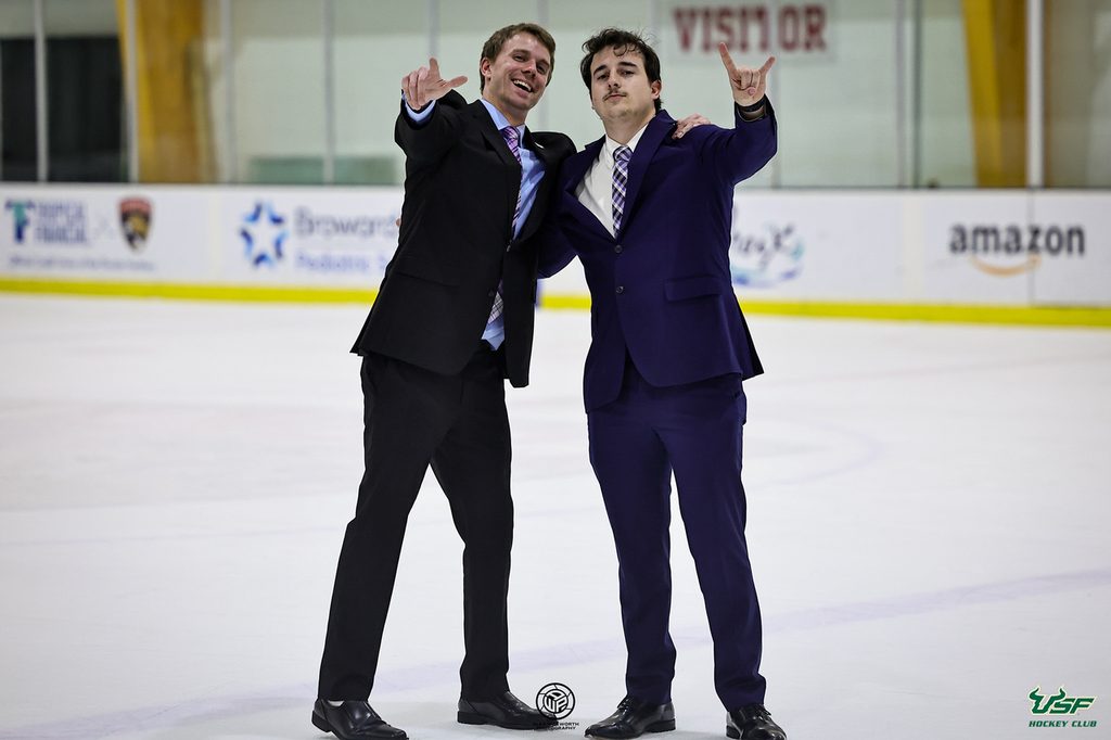 Cameron Churilla and Logan Buggy standing in the ice rink at the AdventHealth Center Ice. Photo cred: @awphoto247