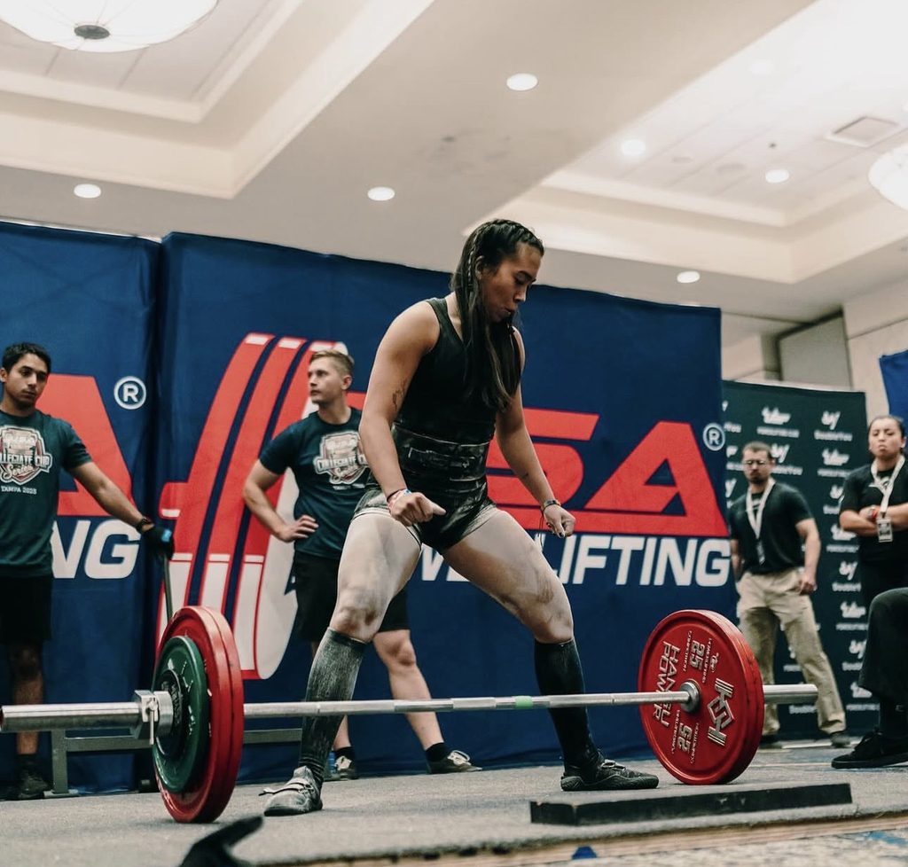 Woman about to lift a large weight.