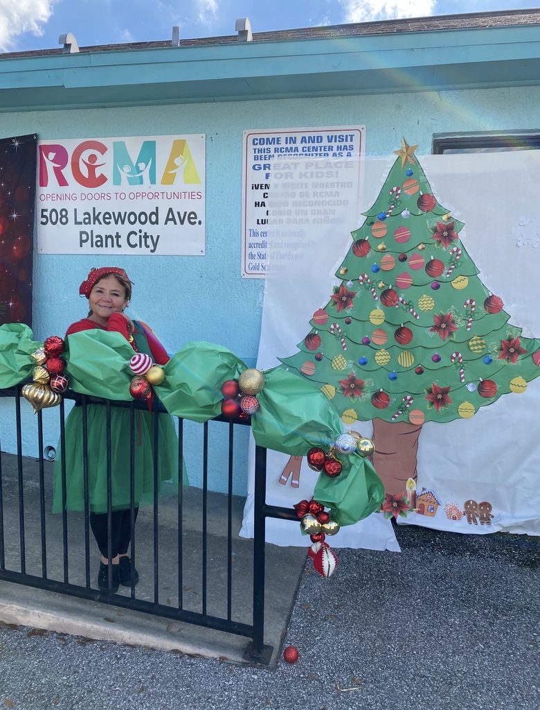 Maria Estrella dressed as an elf and poses outside the RCMA center during Christmas.