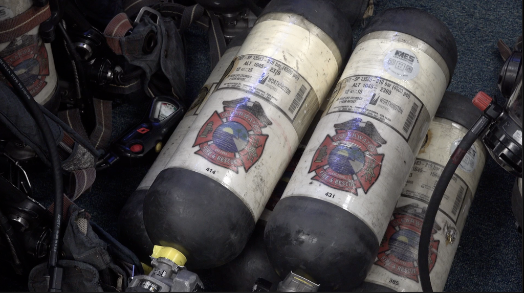 This is two oxygen tanks sitting on top of another oxygen tank